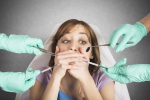 Startled woman covering her mouth while gloved hands hold instruments