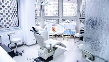 Behandlungszimmer mit Stuhl und Leuchte am Fenster
